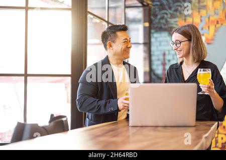 Friends talk and drink beer in bar Stock Photo