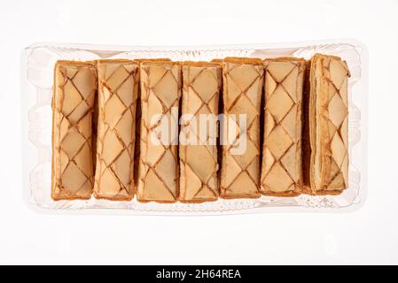 Cookie Sfogliatine, glazed puff pastry biscuits in plastic tray for sale. Italian dessert isolated on white , top view Stock Photo