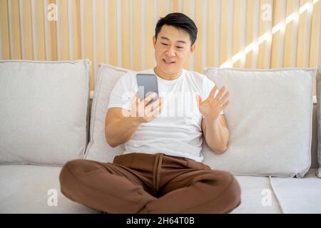 Asian man having video call on smartphone Stock Photo