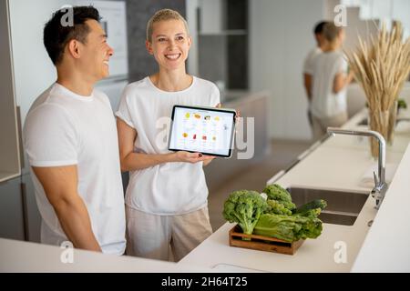 Man and girl show online food store on gadget Stock Photo
