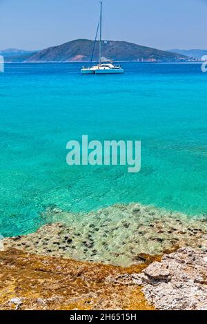 Exotic beach of crystal clear turquoise waters at Moni islet, close to Aegina island, in Attica region, Greece, Europe. Stock Photo