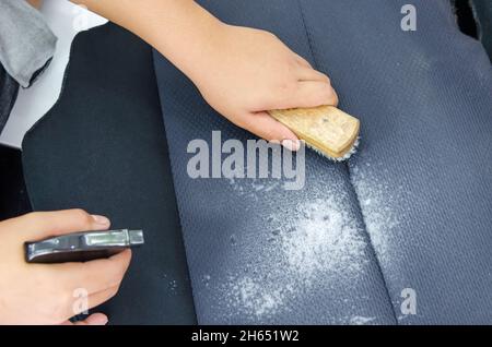 man with a hand to scrub brush to clean upholstery Stock Photo