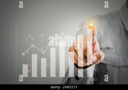 Businessman present a graph of profit growth and chart.Hands are touching financial graph plan Stock Photo
