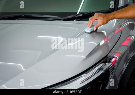 mechanic is coating ceramic glass to prevent scratches on cars. Stock Photo