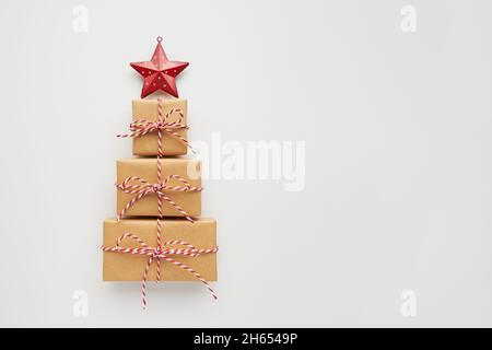 Christmas tree made of gift boxes and decorative star on white background. Top view, flat lay, copy space. Stock Photo