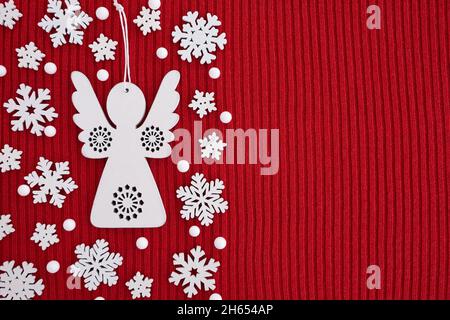 Border made of wooden Christmas decorations on red knitted background. Top view, flat lay, copy space. Stock Photo