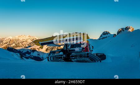 Snowplow on a snowy road. Snow grooming. Snow groomer Stock Photo