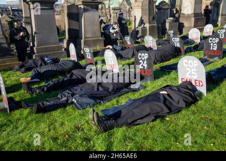 The Red Rebel Brigade join the Blue Rebel Brigade at the Glasgow Necropolis graveyard for the funerary of COP26. The weeping climate activists feel that COP26 is a failure and have held a mock funeral for the summit. COP26 is laid to rest in a grave alongside all of the previous COP summits. Stock Photo