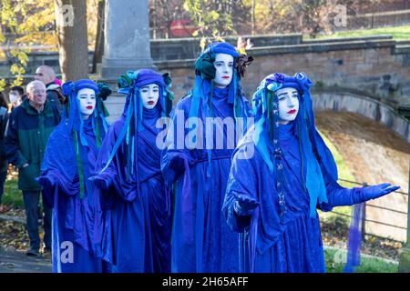 The Red Rebel Brigade join the Blue Rebel Brigade at the Glasgow Necropolis graveyard for the funerary of COP26. The weeping climate activists feel that COP26 is a failure and have held a mock funeral for the summit. COP26 is laid to rest in a grave alongside all of the previous COP summits. Stock Photo