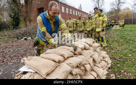 Neumunster, Germany. 13th Nov, 2021. 13 November 2021, Schleswig-Holstein, Neumünster: Firefighters from the Garding Volunteer Fire Department practice passing and stacking sandbags in a way that is easy on the body. This is not normally part of their training, as disaster control and dike defense are tasks of the THW (Technisches Hilfwerk). In the future, however, the Garding Fire Department also wants to be prepared for possible flooding. Photo: Markus Scholz/dpa Credit: dpa picture alliance/Alamy Live News Stock Photo
