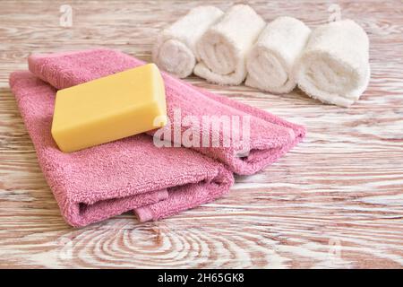 Bar of soap lies on folded terry towels, close-up, shallow depth of field Stock Photo