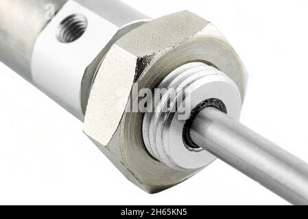 A macro photo of a piston rubber seal from a pneumatic air cylinder with a thread and a nut on the end, isolated on a white background. Stock Photo