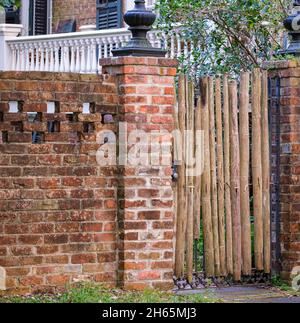 NEW ORLEANS, LA, USA - OCTOBER 15, 2021: Old brick wall and makeshift bamboo gate in Uptown New Orleans Stock Photo