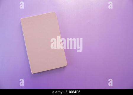 Purple notebook, top view of notebook isolated on purple background. Copy space, flat lay. Stock Photo