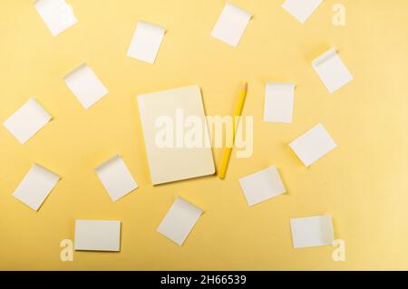 Notepad and lots of stickers. Stickers for tasks on the table. Many tasks and solutions. Notepad and pencil. Stock Photo