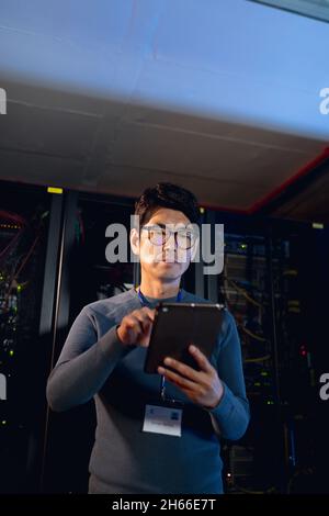Asian male engineer using digital tablet in computer server room Stock Photo