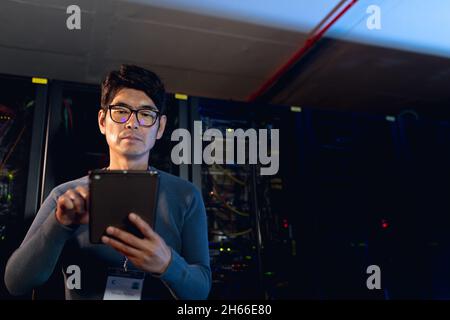 Asian male engineer using digital tablet in computer server room Stock Photo