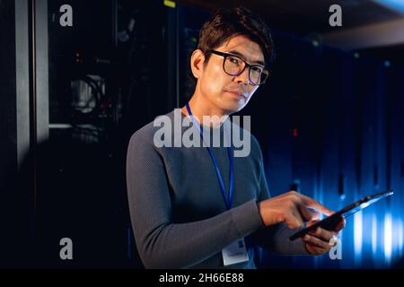 Portrait of asian male engineer using digital tablet in computer server room Stock Photo