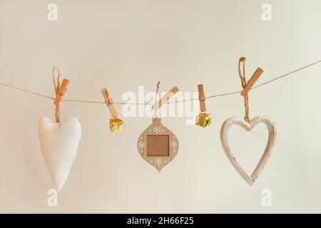 white and golden christmas decorations pinned on rope. Fabric and textile ornament hanging on white Stock Photo