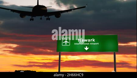 Airplane silhouette landing in Newark, New Jersey, USA. City arrival with airport direction signboard and sunset in background. Trip and transportatio Stock Photo