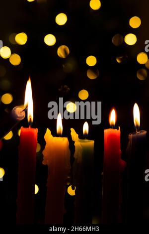 Candlelight Day. Traditional Colombian holiday. Group of colored candles lit at night with unfocused lights in the background. Copy space. Stock Photo