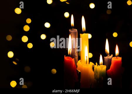 Candlelight Day. Traditional Colombian holiday. Group of colored candles lit at night with unfocused lights in the background. Copy space. Stock Photo