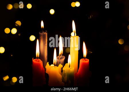 Candlelight Day. Traditional Colombian holiday. Group of colored candles lit at night with unfocused lights in the background. Copy space. Stock Photo