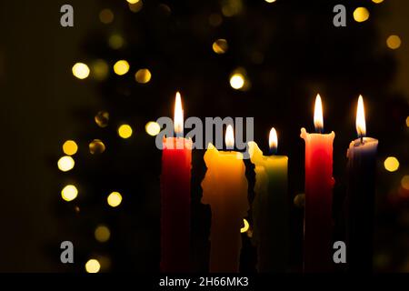 Candlelight Day. Traditional Colombian holiday. Group of colored candles lit at night with unfocused lights in the background. Copy space. Stock Photo