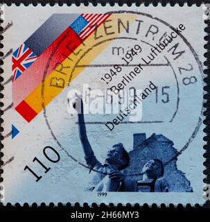 GERMANY - CIRCA 1999 : a postage stamp from Germany, showing the flags of the Allies (US, GB, F) and two boys on the blockade of Berlin by the Soviet Stock Photo