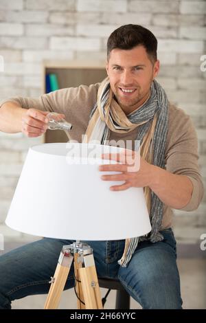 man replacing the bulb in a lamp Stock Photo