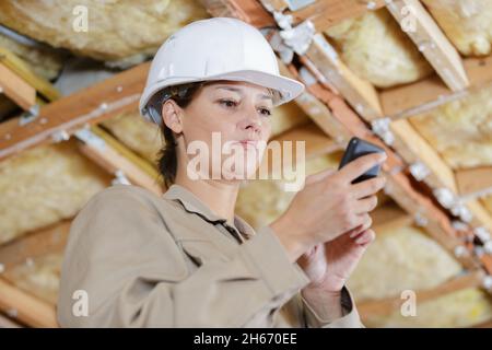 woman builder with blueprints using smart phone Stock Photo