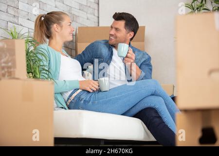 happy couple taking break unpacking on moving day Stock Photo