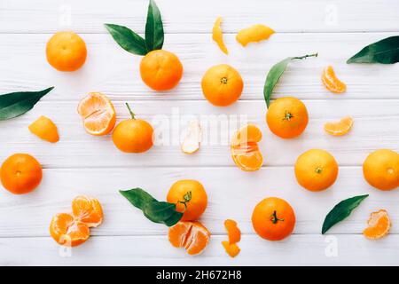 Fresh clementines with leaves on white wooden table. Stock Photo