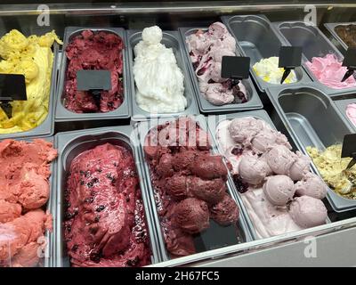 A multi-colored dessert, ice cream of different flavors, on the showcase of a cafe. Childhood tastes of different colors. Stock Photo