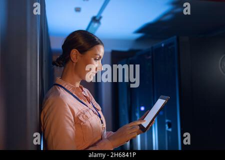 Caucasian female engineer using digital tablet in computer server room Stock Photo