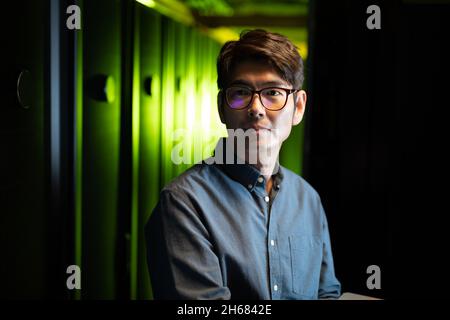 Asian male engineer using laptop in computer server room Stock Photo