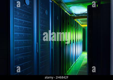 Data center with multiple rows of fully operational server racks Stock Photo