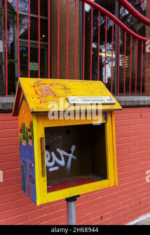 Calgary, Canada - November 13, 2021: Neglected roadside Little Free Library box in downtown Calgary Chinatown. A Little Free Library is a free book-sh Stock Photo