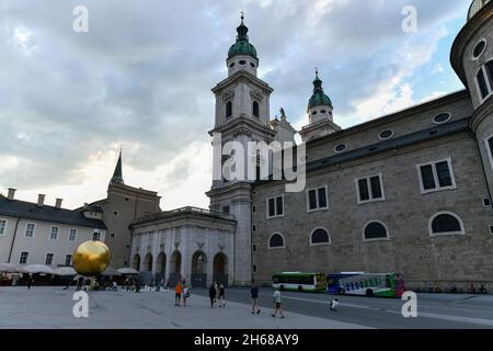 Salzburg, Austria - July 10, 2021: Kapitelplatz square with a sculpture of a man on a golden sphere in Salzburg City. Stock Photo