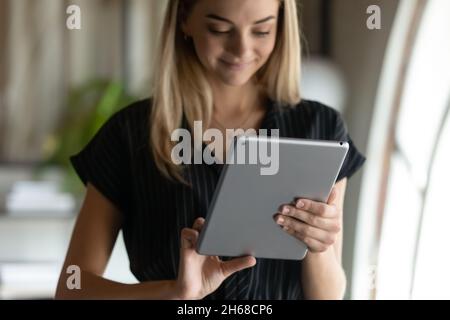 Smiling attractive young businesswoman using touchpad in office. Stock Photo