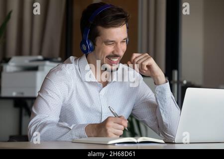 Joyful sincere young latino employee studying remotely. Stock Photo