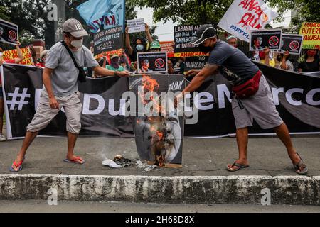 November 14, 2021: Filipino activists burn a placard bearing face images of Davao City Mayor Sara Duterte and son of the late dictator Ferdinand Marcos during a protest against government officials who filed their certificate of candidacy in the 2022 national elections in front of the Commission on Human Rights in Quezon City, Metro Manila, Philippines. November 14, 2021. The daughter of Philippine President Rodrigo Duterte filed papers on Saturday to run for vice president in the 2022 general election, ending speculation she would seek the country's highest office, but prompting the son of Stock Photo