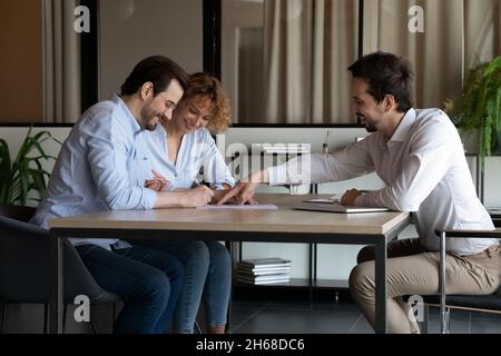Smiling young specialist making agreement with clients. Stock Photo