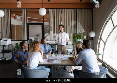 Happy young hispanic male leader holding negotiations meeting. Stock Photo