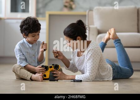 Happy Indian mom and little son playing motor mechanic games Stock Photo