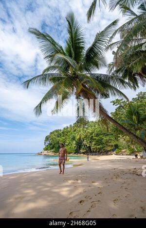 Surin beach in Phuket, southern of Thailand, famous tourist destination in Phuket, Beautiful beach, View of nice tropical beach with palms around. couple man and woman on beach Stock Photo