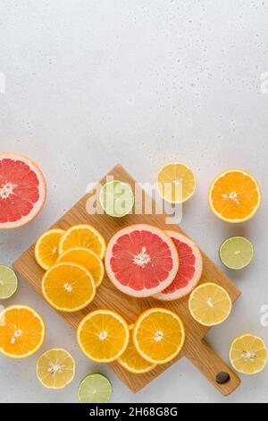 Exotic citrus lobule composition on chopping board. Many juicy halved lemons, limes, grapefruits. Vitamin c healthy varation. Summer mood. Vivid tropi Stock Photo