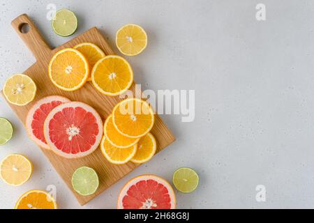 Colorful juicy summer oranges, grapefruits, limes, lemons on wooden board. Sliced fruits full of vitamic C. Assorted composition of ripe multifruits. Stock Photo