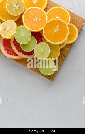 Exotic citrus composition on cutting board. Many juicy halved lemons, limes, grapefruits. Vitamin c healthy varation. Summer mood. Vivid tropical ripe Stock Photo