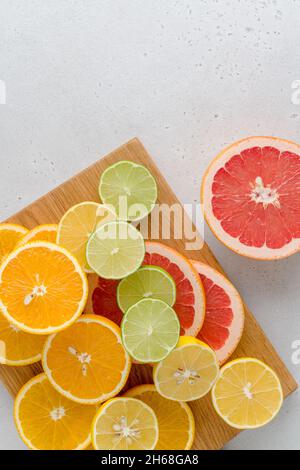 Exotic citrus lobule composition on cutting board. Many juicy halved lemons, limes, grapefruits. Vitamin c healthy varation. Summer mood. Vivid tropic Stock Photo